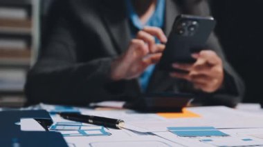 İş adamı elinde akıllı telefon tutuyor ve ofiste tablet kullanıyor..