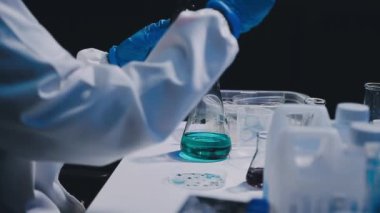 Laboratuvarda kimyasal laboratuvar ekipmanlarıyla çalışan bilim adamlarının yakın çekimi