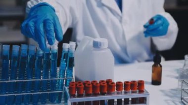 Test tüpleri ve sıvıyla laboratuvar çalışanı.