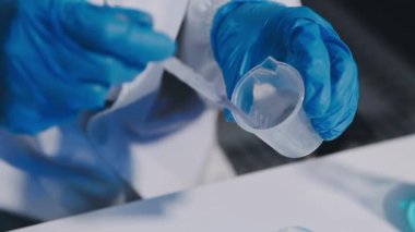 Mavi sıvıyı tutan ellere yaklaş