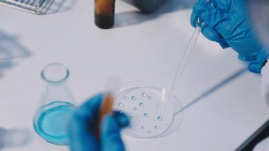 Bilim adamı elinde bir tüp sıvı ile deneyi hazırlıyor..