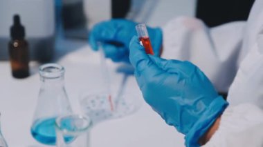 Laboratuvar bilim adamı test tüpleri tutuyor.