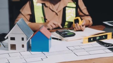 Genç bayan mühendis ofiste çalışıyor. İşyerinde proje ve inşaat araçlarına sahip mimar mühendisi.