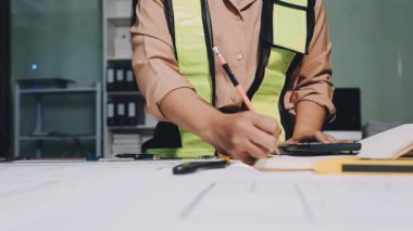 İnşaat alanının planlarıyla çalışan işçi mühendisi.