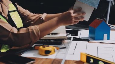 Ofisteki planlarla çalışan mimar mühendisi.