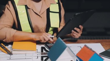 İnşaat alanında proje ve tabletle çalışan mühendis.