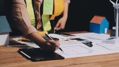 Masada hesap makinesi ve planla çalışan mühendis mimar.