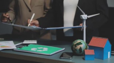 Ofisinde ev modeli olan bir iş adamı.