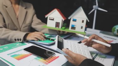 İş adamı ve iş kadını evde hesap makinesi ve hesap makinesiyle çalışıyorlar..