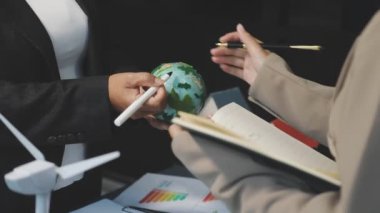 Ofiste elinde kalem ve yazı tutan bir işadamı.