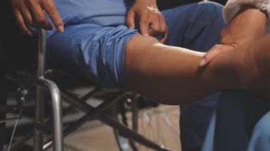 Doktor bacağı olan bir kadının dizini muayene ediyor.