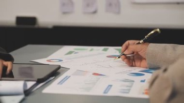 Ofis masasındaki belgeye işaret eden işadamı