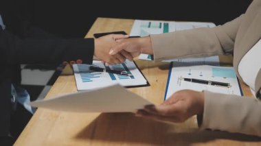 Yakın çekim. Ofisteki bir toplantıda iş ekibi el sıkışıyor.