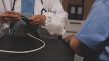 Kadın doktor hastanenin koğuşunda tablet bilgisayar kullanıyor..