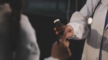 Steteskoplu bir doktor hastanede şırınga tutuyor.