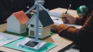 Beyaz gömlekli, kağıttan evi olan bir adam.