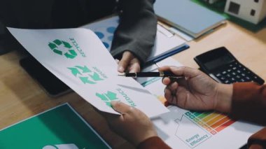 Evrak işleriyle uğraşırken erkek ellerinin elinde yeşil bir kalem ve kağıda yazı tutmasını kapat.