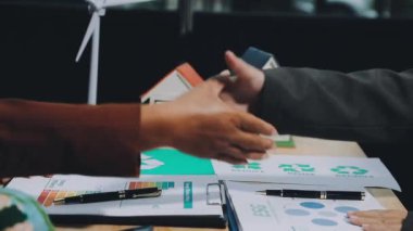 Genç iş adamı ortağıyla tokalaşıyor.