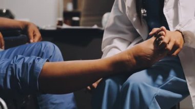 Erkek doktor hastanede ayağına masaj yapıyor.