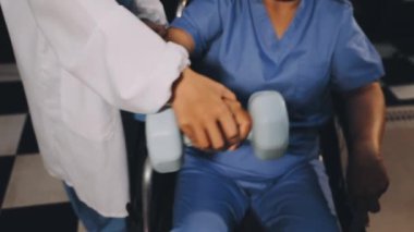 Hastanede hastayı tekerlekli sandalyede tutan doktor.