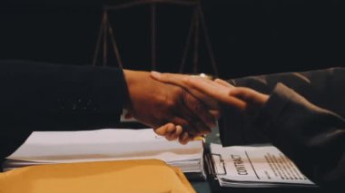 İş adamları el sıkışıyor, sözleşme imzalıyor.