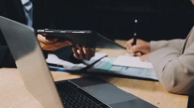 İşadamları yeni fikirleri tartışıyor ve ofiste bir dizüstü bilgisayar üzerinde çalışıyorlar..