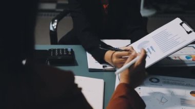 Genç Asyalı iş kadını ofiste çalışıyor. Finansal planı ve mali verileri ofiste tartışan genç iş adamları.