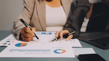 İş yerinde dizüstü bilgisayarla evrak üzerinde çalışan iş kadınlarının yakın çekimleri. iş kavramı.