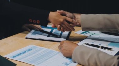 İş adamı el sıkışırken ofiste bir iş anlaşması yapıyor.