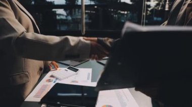 İş adamı ve iş kadını iş toplantısı sırasında el sıkışıyor