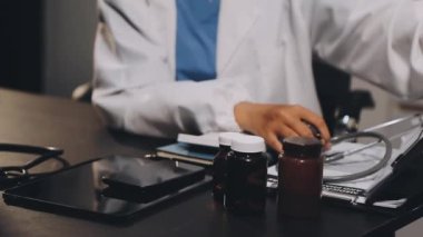 Steteskoplu bir doktor ve genç bir hastanın elinde bir tablet..