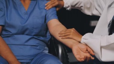 Hasta eli üzerinde üniformalı bir doktor.