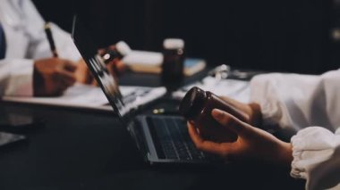 Yakın plan. Hastanedeki bir hastayı kontrol etmek için dizüstü bilgisayar kullanan genç bir doktorun görüntüsü.