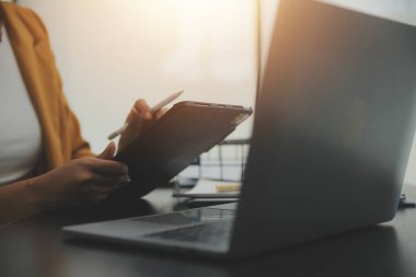 Hesap makinesi ve dizüstü bilgisayarı kullanarak ahşap masa, vergi, muhasebe, istatistik ve analitik araştırma konseptine matematik finansmanı sağlayan İş kadını kapat