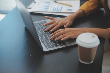 Hesap makinesi ve dizüstü bilgisayarı kullanarak ahşap masa, vergi, muhasebe, istatistik ve analitik araştırma konseptine matematik finansmanı sağlayan İş kadını kapat
