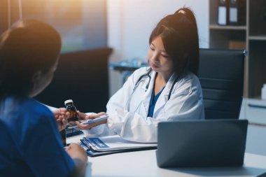 Ofiste çalışan ve hastayı dinleyen doktor semptomlarını, sağlık hizmetlerini ve yardım kavramlarını açıklıyor.