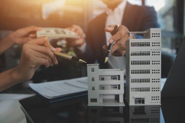 Emlakçı ve müşteri ev, sigorta ya da emlak satın almak için sözleşme imzalarlar. Ev kiralarlar, sigorta yaptırırlar, emlak veya emlak kredisi alırlar..