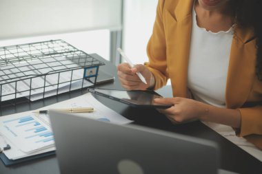 Hesap makinesi ve dizüstü bilgisayarı kullanarak ahşap masa, vergi, muhasebe, istatistik ve analitik araştırma konseptine matematik finansmanı sağlayan İş kadını kapat