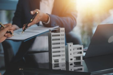 Emlakçı ve müşteri ev, sigorta ya da emlak satın almak için sözleşme imzalarlar. Ev kiralarlar, sigorta yaptırırlar, emlak veya emlak kredisi alırlar..