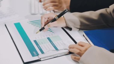 İş dünyası ekibi laptopla ve finansal rapor grafiğiyle çalışıyor.