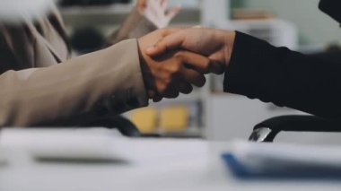 Modern ofisteki toplantı bittikten sonra iş adamları el sıkışıyor.