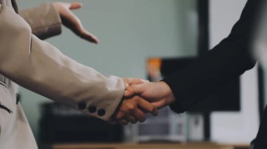 İş adamları ofiste buluştuktan sonra el sıkışıyor, iş adamına yakından bakıyor, iş adamı tokalaşıyor.