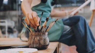 Kadın sanatçı fırçayla resim yapıyor.