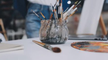 Sanatçının işyeri. Sanatçı tuvale resim çiziyor ve resim yapıyor..