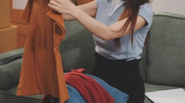 Kadın elleri oturma odasında kahverengi bir çanta tutuyor.