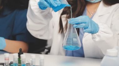 Yakın plan - laboratuvarda kimyasal sıvıyla tüpü tutan bilim adamının görüntüsü