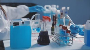 Test tüpleri tutan bir laboratuar asistanını kapat