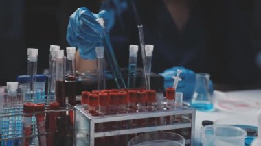 Yakın plan. Kimya laboratuvarının arka planında sıvı bulunan bir tüp var.