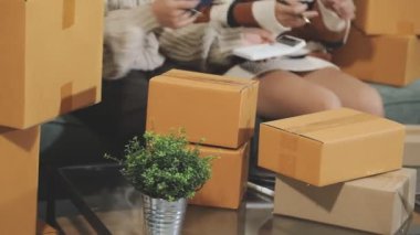 Evde kutular ve karton kutularla bir kadın var.
