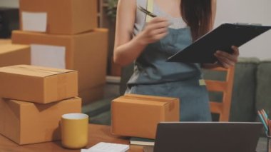 İş kadını ofiste dizüstü bilgisayar ve paket kutusuyla çalışıyor.